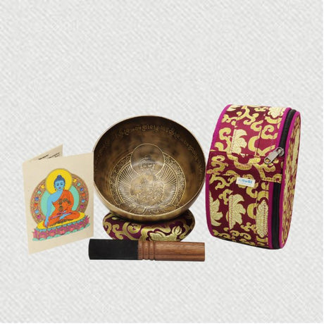 tibetan singing bowl with buddha carving in it and a printed carry bag