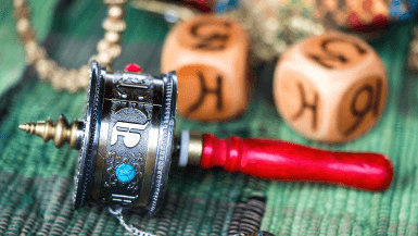 small round metal prayer wheels with prayers written on it